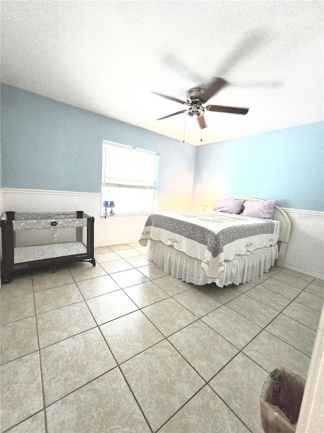 unfurnished bedroom with ceiling fan, light tile patterned flooring, and a textured ceiling