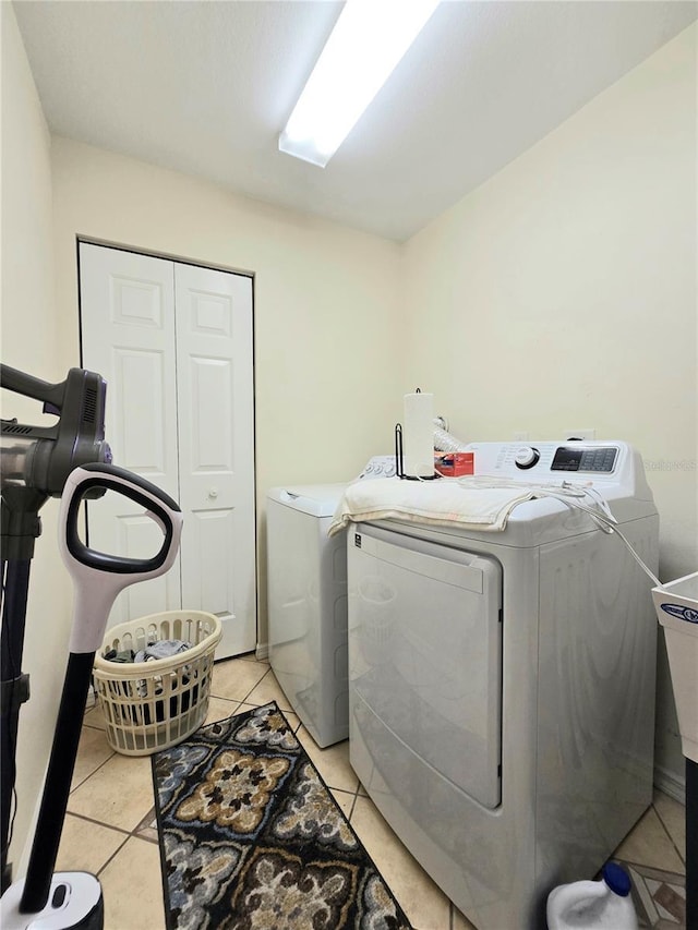 washroom with light tile patterned flooring and washing machine and clothes dryer