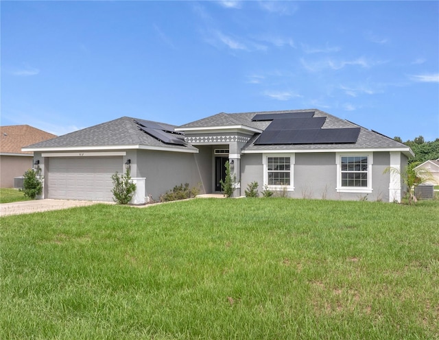 prairie-style house with a front yard, a garage, solar panels, and central AC