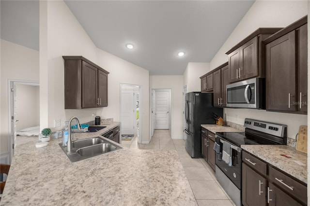 kitchen featuring dark brown cabinets, stainless steel appliances, vaulted ceiling, and sink