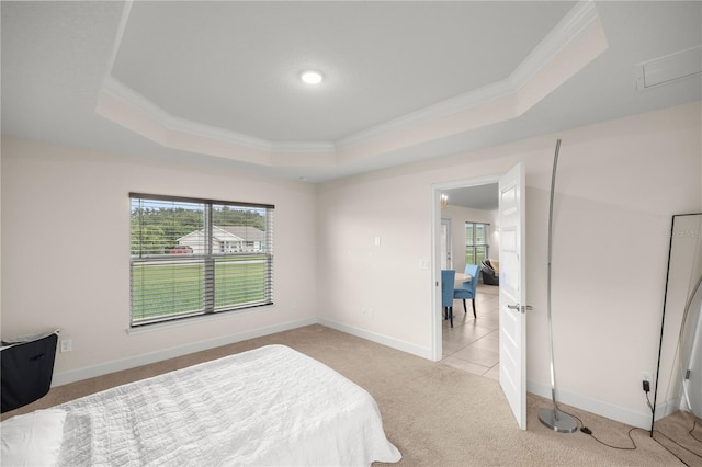 bedroom featuring light colored carpet, a raised ceiling, and crown molding