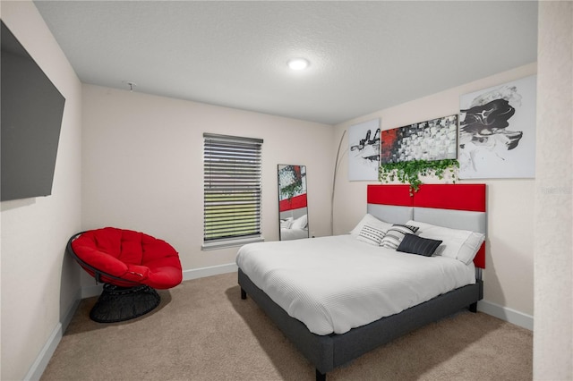 bedroom with a textured ceiling and light carpet