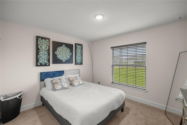 bedroom featuring light colored carpet and a textured ceiling