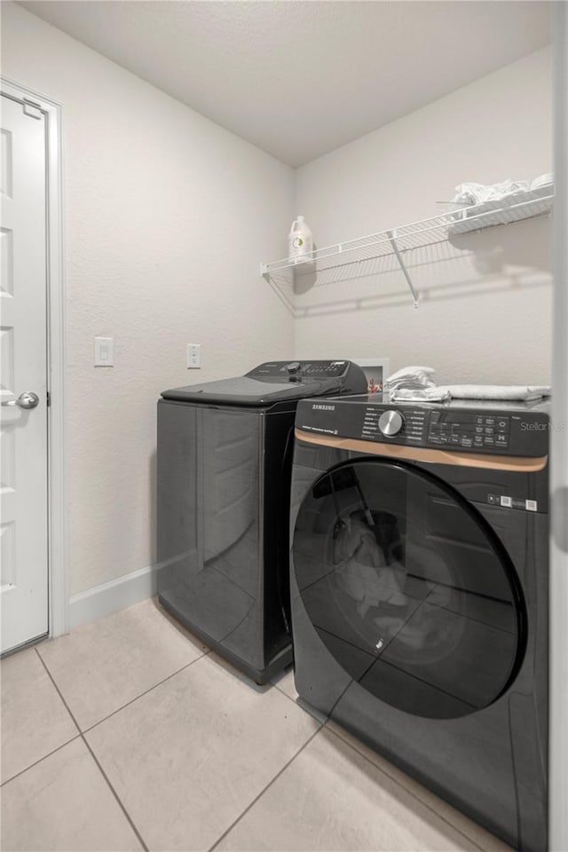 washroom featuring washer and clothes dryer and tile patterned floors