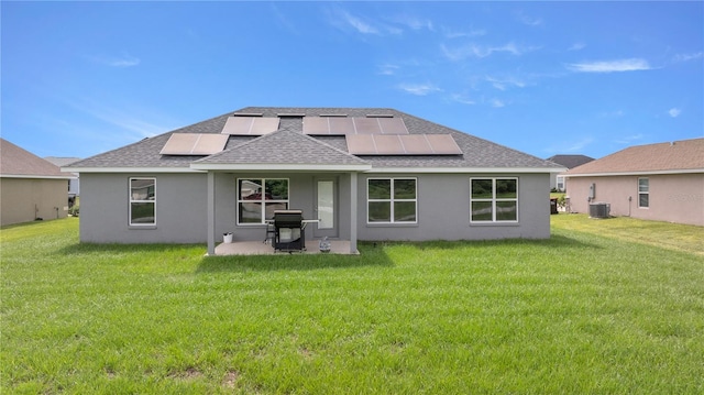 rear view of property featuring solar panels, a yard, a patio, and central air condition unit