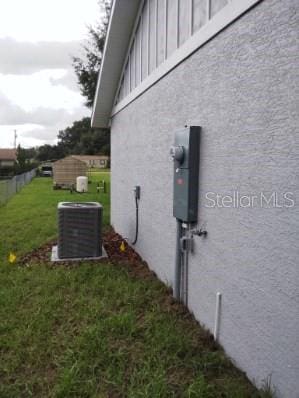 view of property exterior featuring central AC and a yard