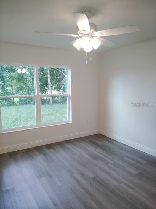 unfurnished room featuring dark hardwood / wood-style floors and ceiling fan