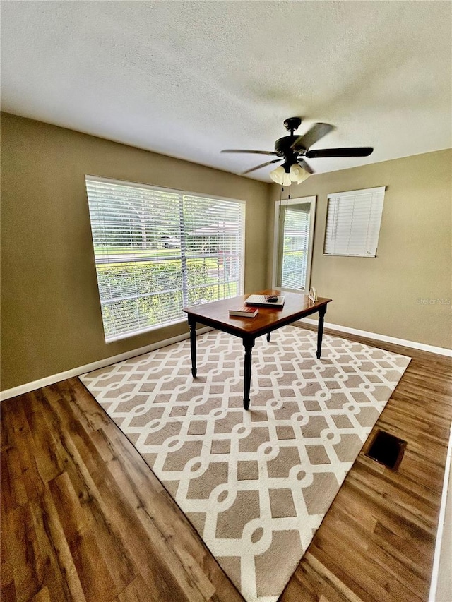 interior space with ceiling fan, hardwood / wood-style flooring, and a textured ceiling