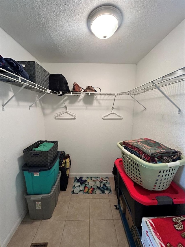 walk in closet with light tile patterned floors