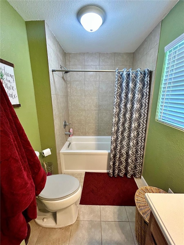 full bathroom featuring a textured ceiling, tile patterned floors, shower / tub combo with curtain, vanity, and toilet