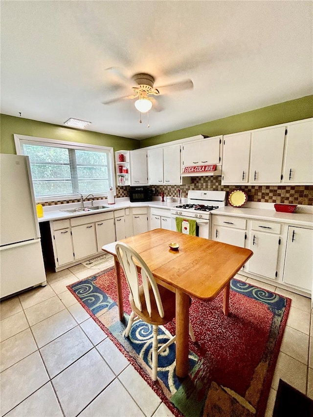 kitchen featuring sink, white cabinets, white appliances, light tile patterned floors, and ceiling fan