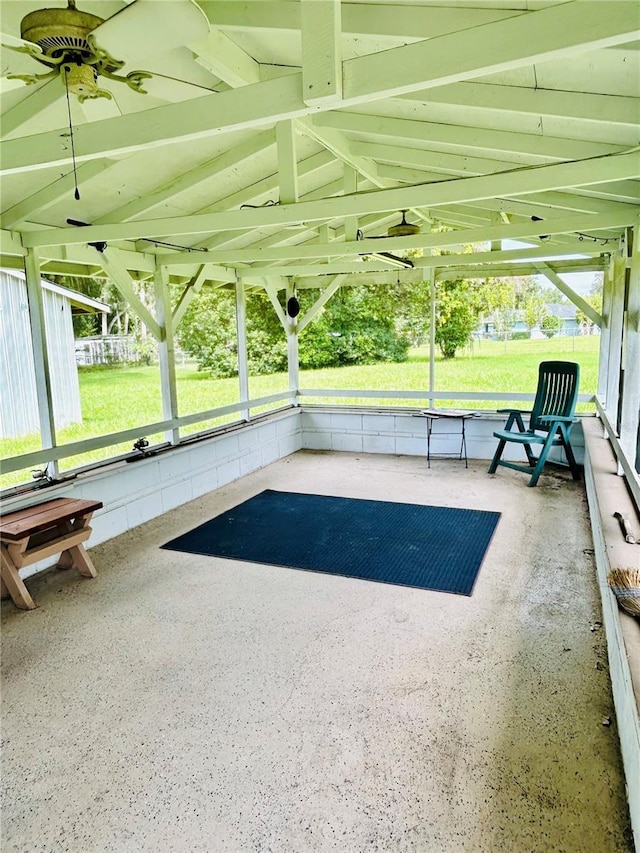 unfurnished sunroom with ceiling fan and vaulted ceiling