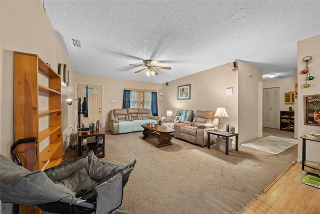 living room featuring a textured ceiling, ceiling fan, and hardwood / wood-style flooring