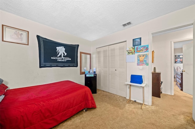 carpeted bedroom featuring a closet and a textured ceiling