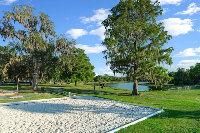 view of home's community featuring a water view, volleyball court, and a yard