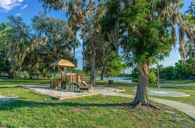 view of playground with a lawn and a water view