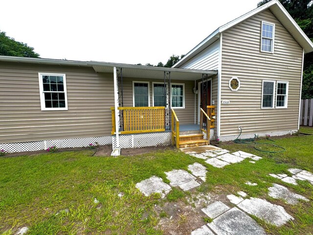 view of front of home with a front yard and a porch