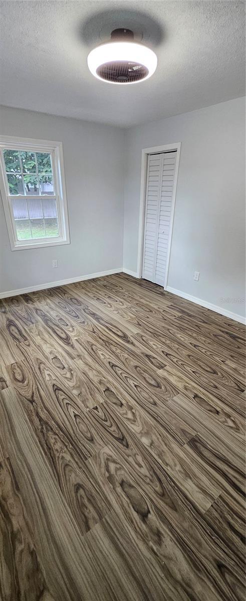 spare room with a textured ceiling and wood-type flooring