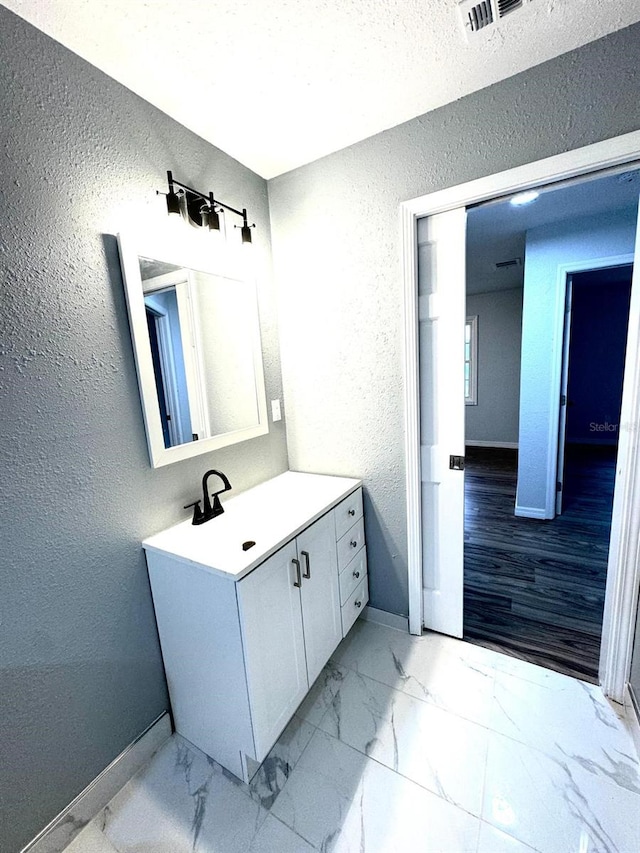 bathroom featuring a textured ceiling and vanity