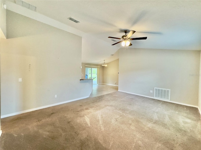 carpeted empty room with ceiling fan with notable chandelier and vaulted ceiling