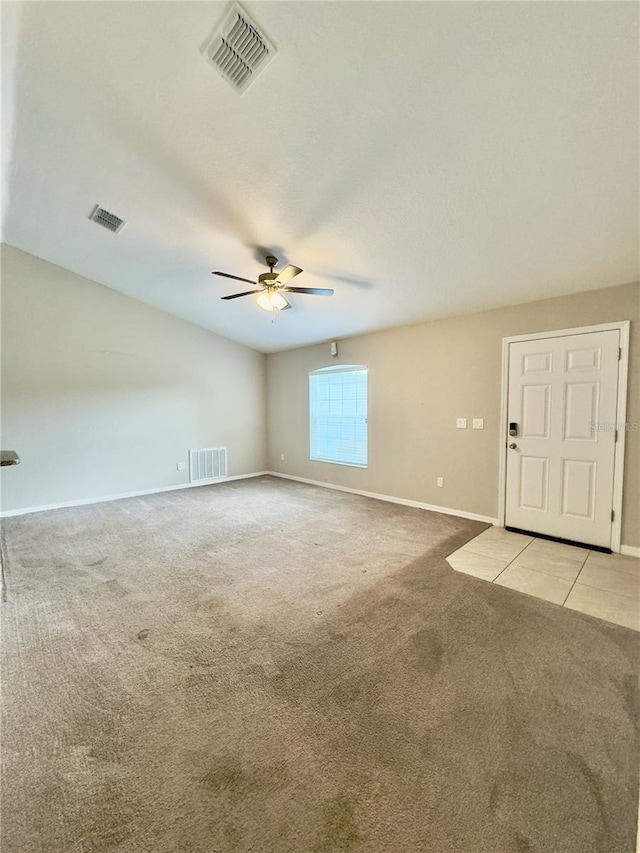 spare room with light colored carpet, ceiling fan, and visible vents