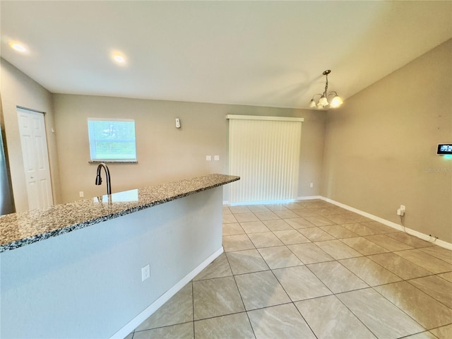 kitchen with hanging light fixtures, light tile patterned flooring, an inviting chandelier, and light stone counters