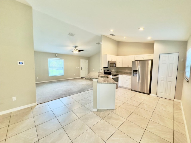 kitchen with white cabinetry, light stone counters, kitchen peninsula, stainless steel appliances, and lofted ceiling