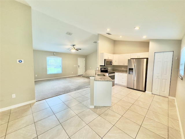 kitchen featuring appliances with stainless steel finishes, a sink, baseboards, lofted ceiling, and white cabinetry