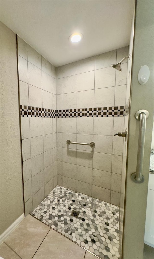 bathroom with tile patterned flooring and tiled shower