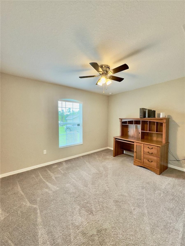 carpeted office featuring ceiling fan and a textured ceiling