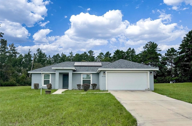 ranch-style home with solar panels, a front yard, and a garage