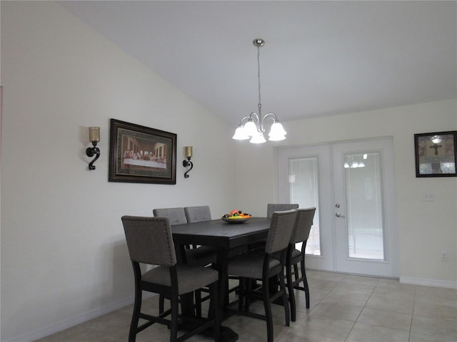 dining area featuring a chandelier, lofted ceiling, light tile patterned floors, and french doors