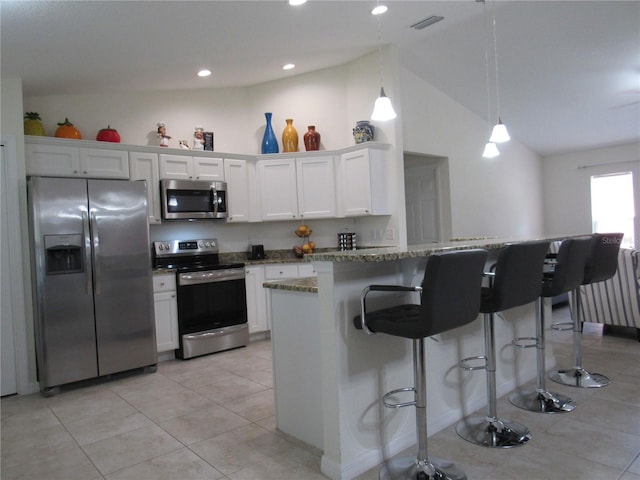 kitchen featuring appliances with stainless steel finishes, white cabinetry, and lofted ceiling