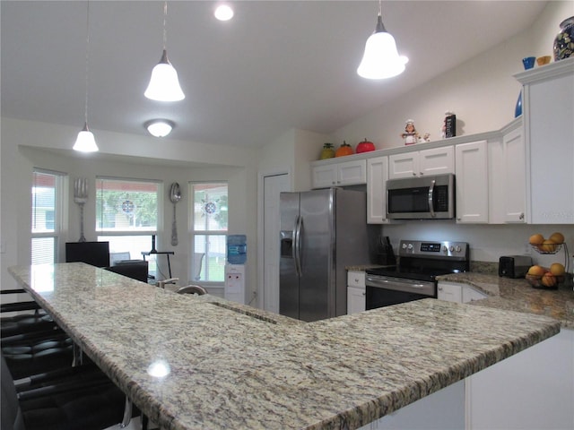 kitchen with pendant lighting, white cabinetry, stainless steel appliances, and vaulted ceiling