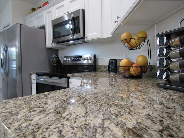 kitchen featuring white cabinets, stainless steel appliances, and stone countertops