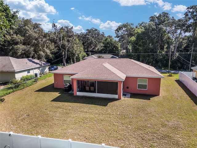 back of house featuring a sunroom and a yard