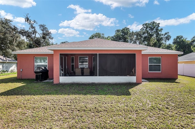 back of house featuring a yard and a sunroom