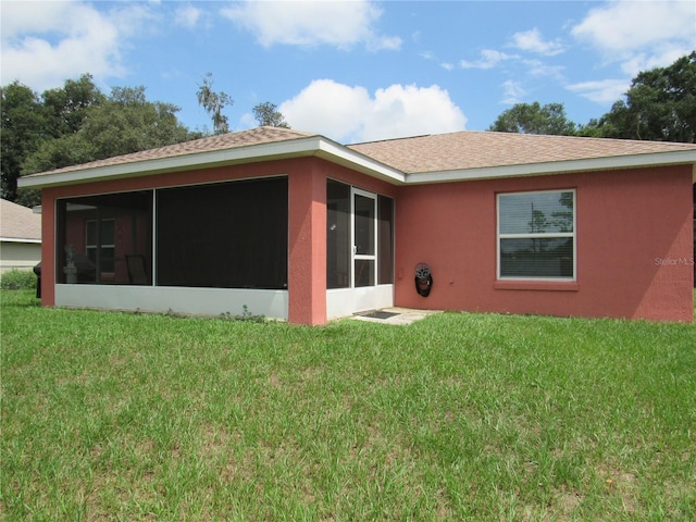 back of house with a yard and a sunroom