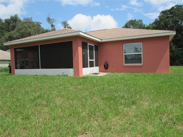 back of property with a sunroom and a yard