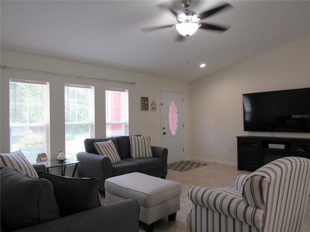 living room with ceiling fan, lofted ceiling, and light tile patterned flooring