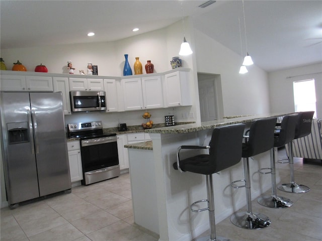 kitchen with white cabinets, pendant lighting, lofted ceiling, and appliances with stainless steel finishes