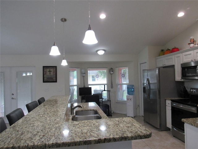 kitchen featuring sink, an island with sink, decorative light fixtures, white cabinets, and appliances with stainless steel finishes