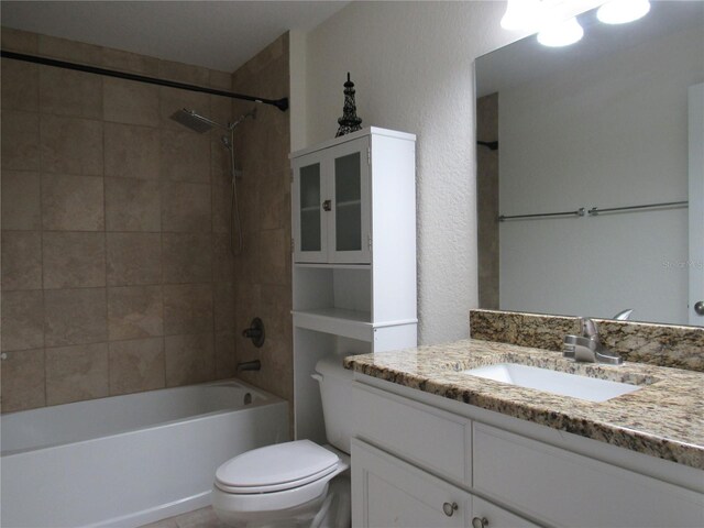 full bathroom with vanity, tiled shower / bath combo, and toilet