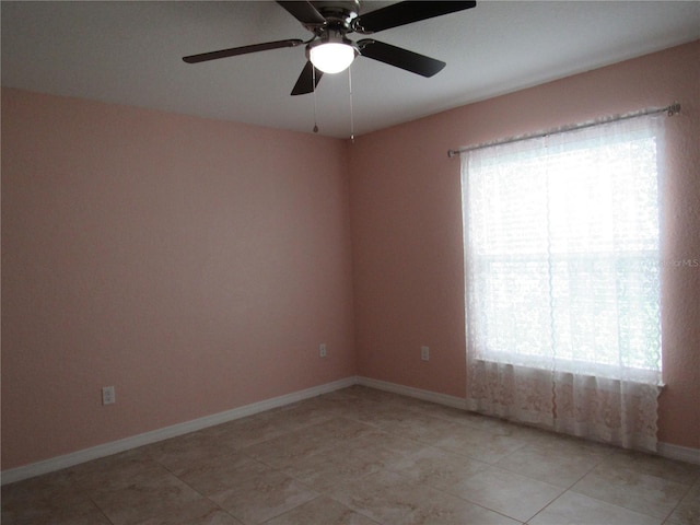 tiled empty room featuring ceiling fan