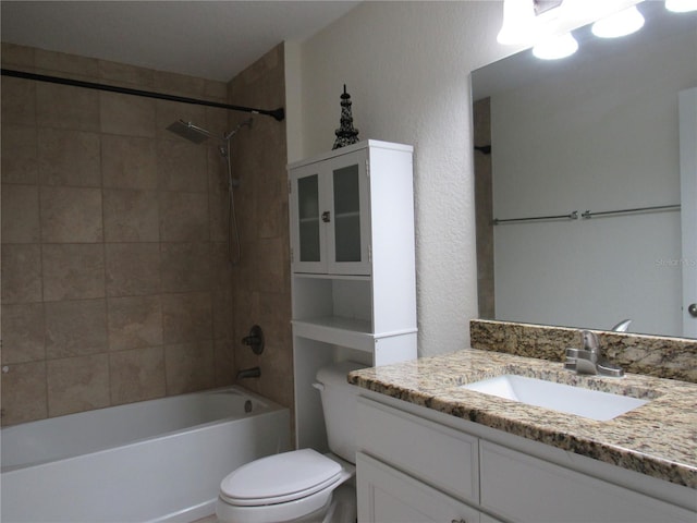 full bathroom with vanity, tiled shower / bath combo, and toilet