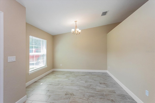 empty room with vaulted ceiling and a notable chandelier