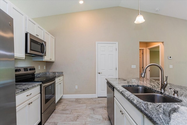 kitchen featuring dark stone countertops, sink, white cabinets, vaulted ceiling, and appliances with stainless steel finishes