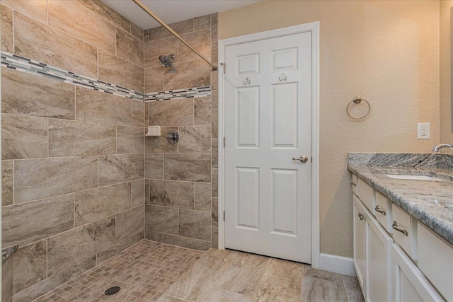 bathroom with vanity and tiled shower