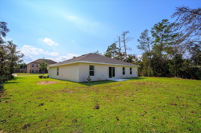 rear view of property featuring a patio area and a lawn