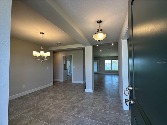 tiled foyer featuring a textured ceiling and a notable chandelier